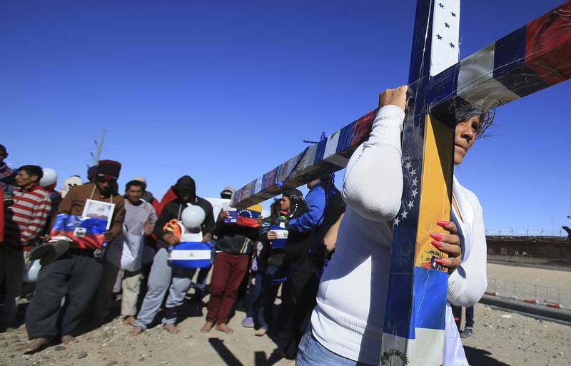 Migrantes participan en la Vía Crucis en Ciudad Juárez, Chihuahua; cada integrante camina con la cruz unos pocos metros