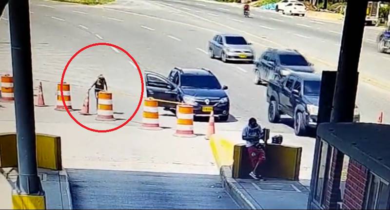 Imagen de una mujer que se roba un cono de tránsito.