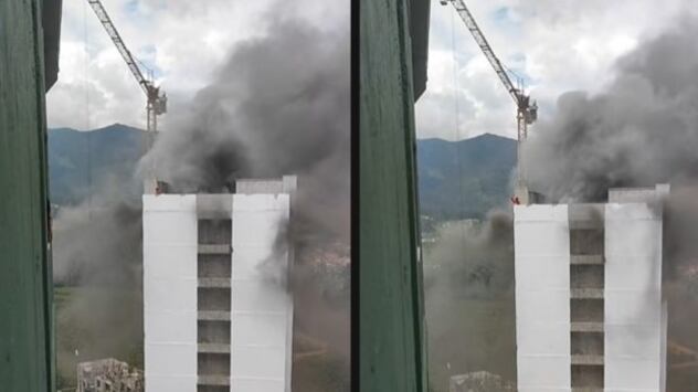 Foto del instante del rescate de un obrero por su compañero en las alturas de un edificio en llamas.