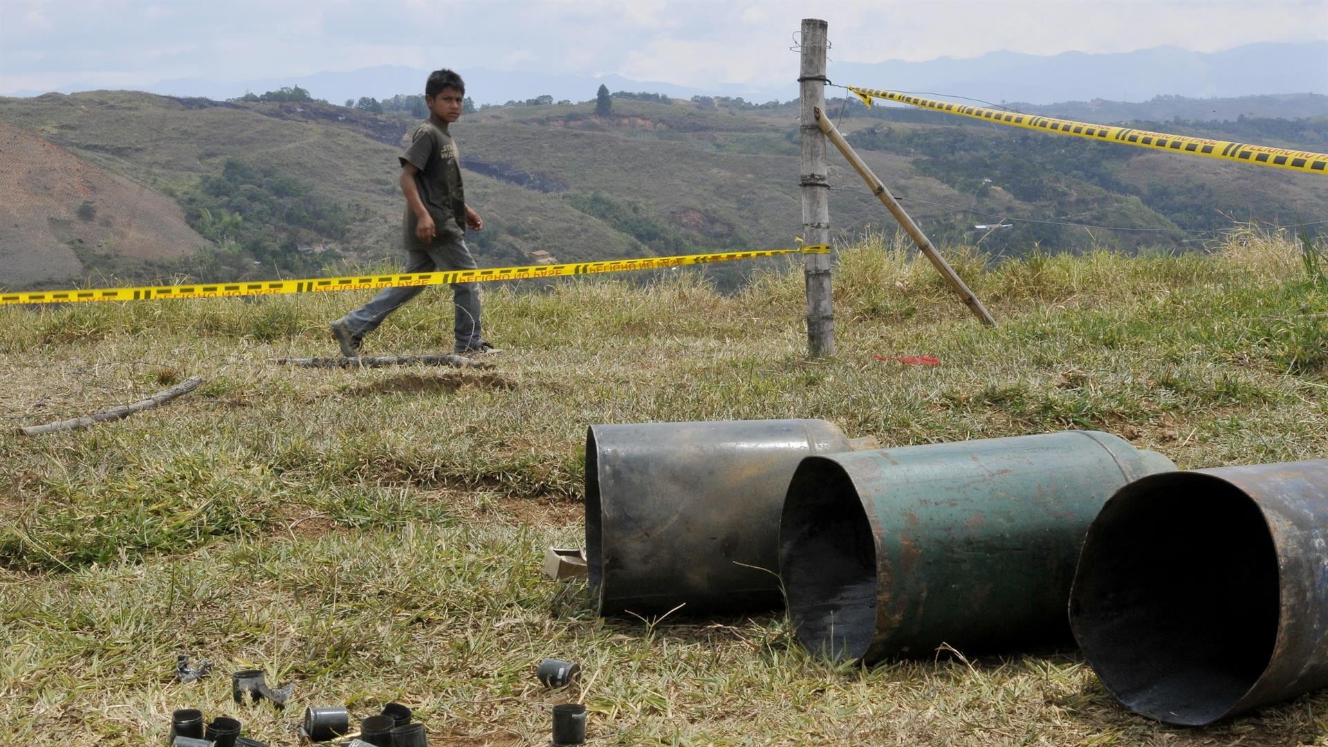 Un niño camina junto a unos cilindros bomba encontrados en el resguardo indígena de Las Mercedes hoy, sábado 11 de agosto de 2012, en Caldono, Cauca (Colombia).