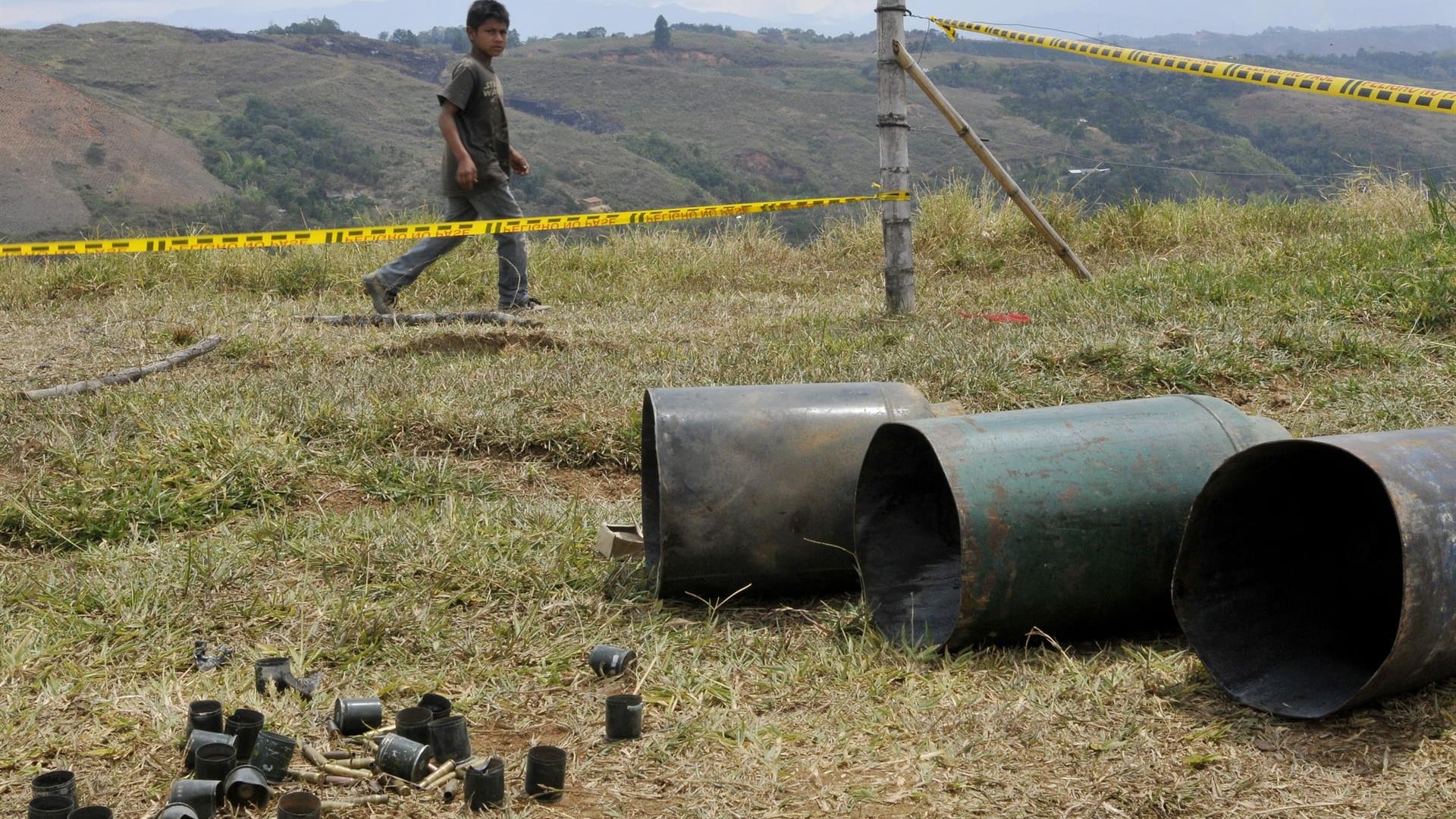 Un niño camina junto a unos cilindros bomba encontrados en el resguardo indígena de Las Mercedes hoy, sábado 11 de agosto de 2012, en Caldono, Cauca (Colombia).
