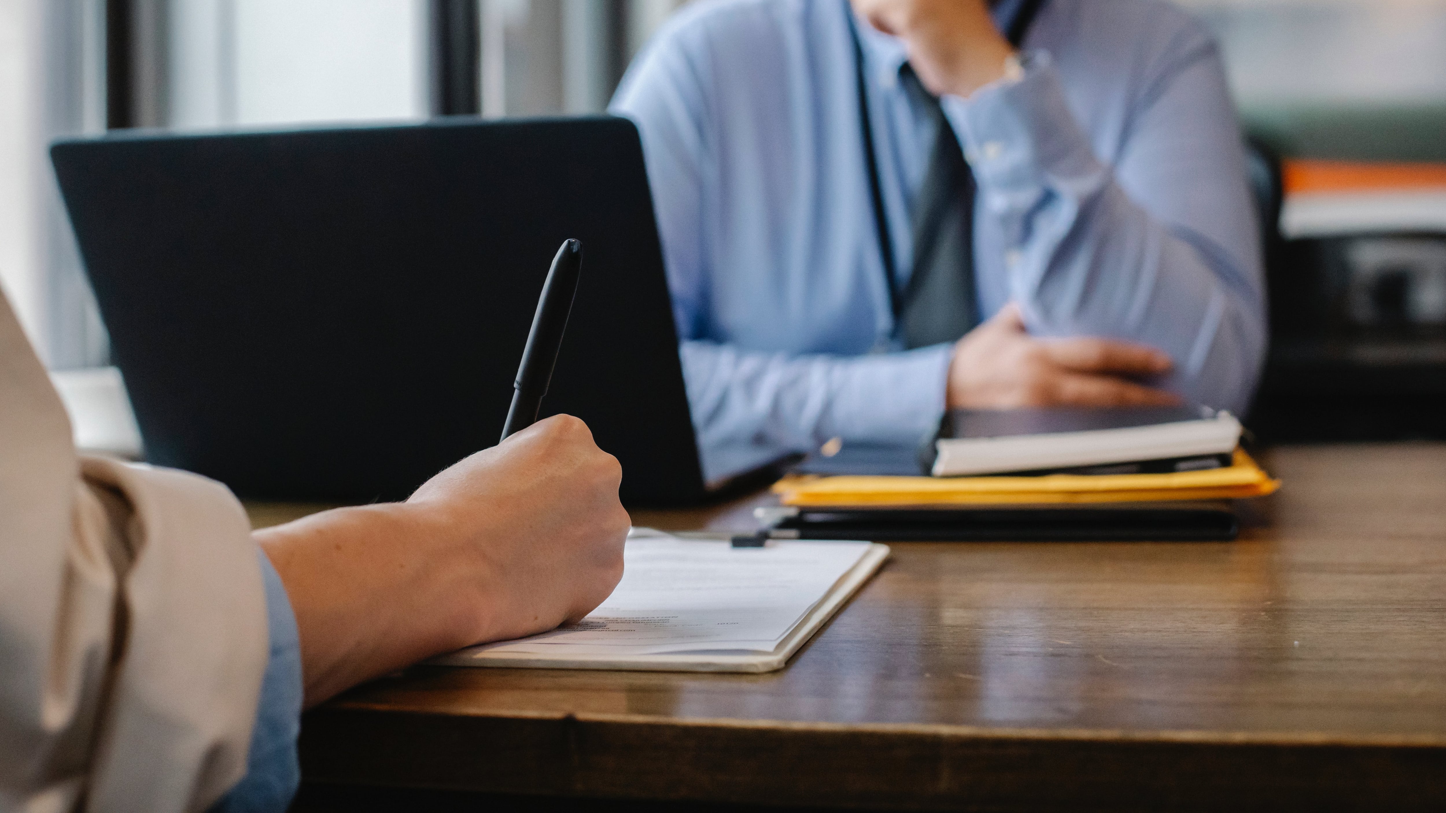 Homem com camisa social azul em frente ao computador