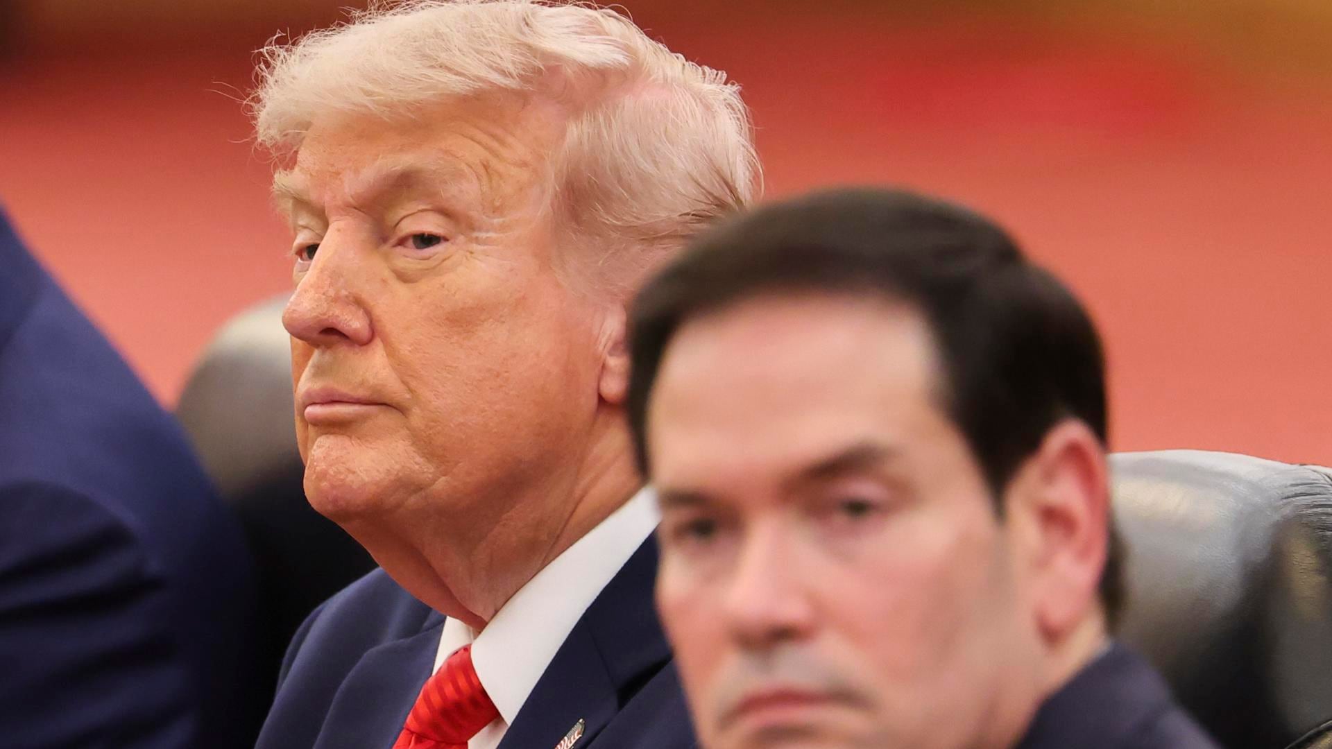 Donald Trump (D), sentado junto a su secretario de Estado, Marco Rubio