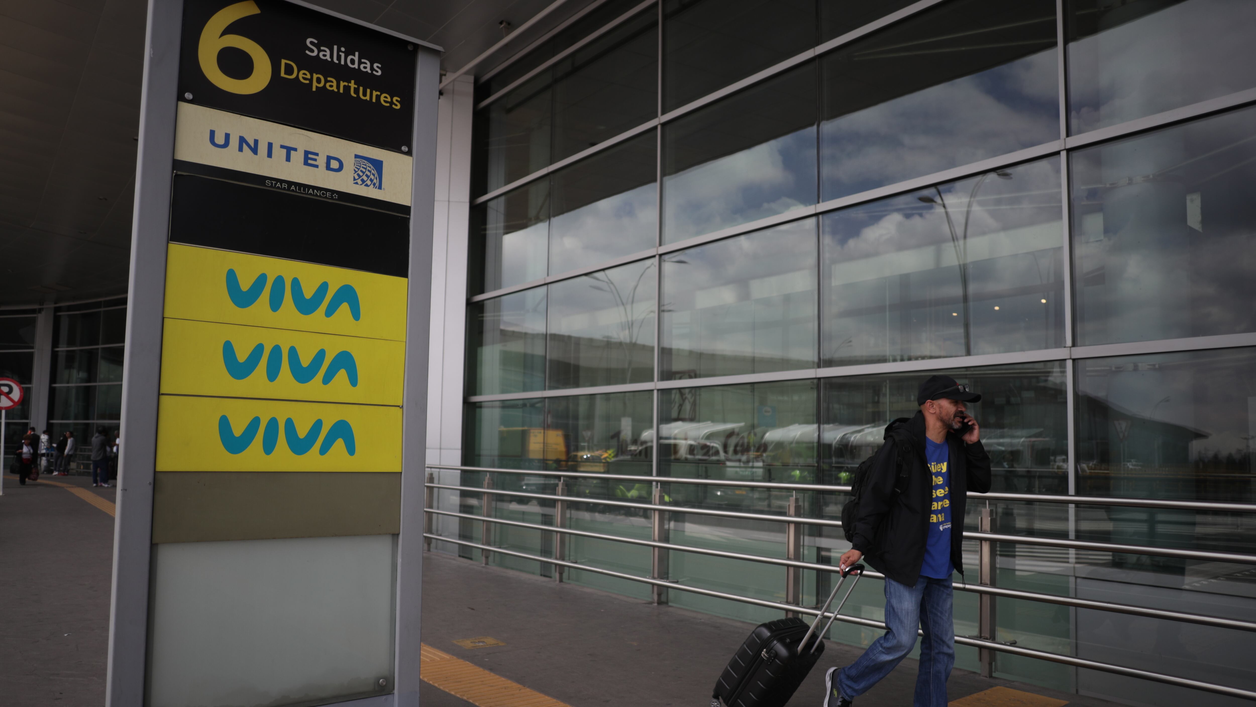 Un pasajero circulas en las afueras del aeropuerto El Dorado de Bogotá, cerca a los counters de la aerolínea Viva Air