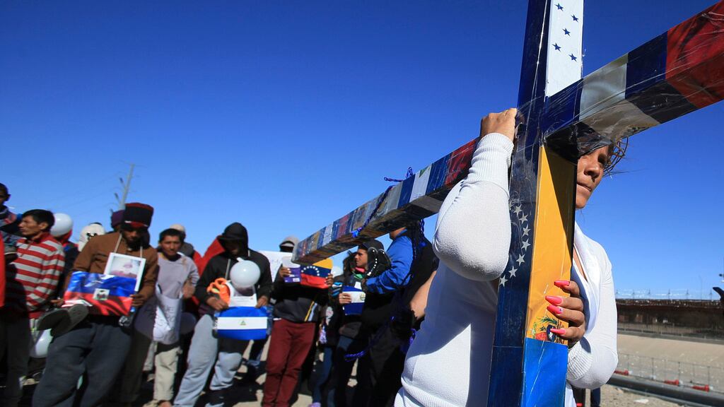 Migrantes participan en la Vía Crucis en Ciudad Juárez, Chihuahua; cada integrante camina con la cruz unos pocos metros