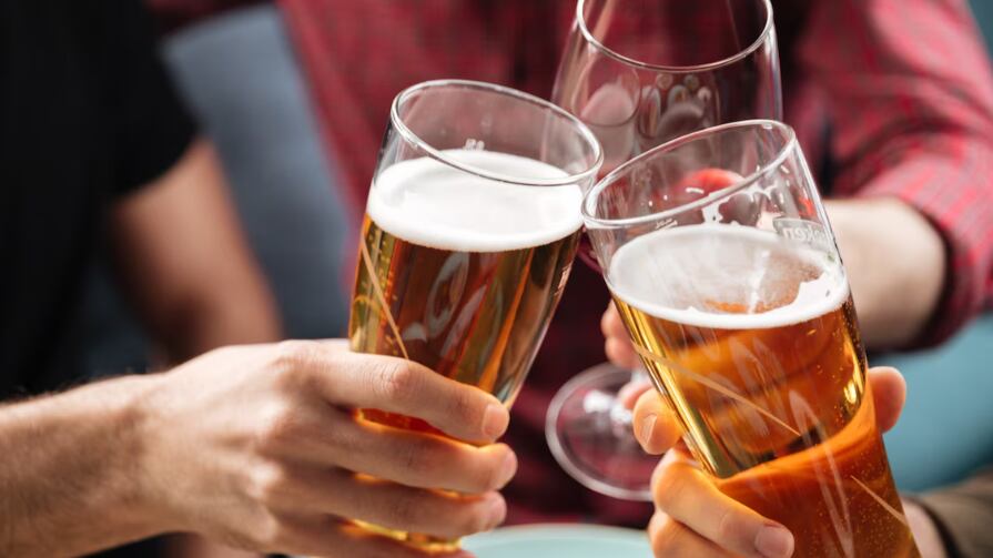 Jóvenes amigos sentados en la cafetería mientras bebe alcohol.