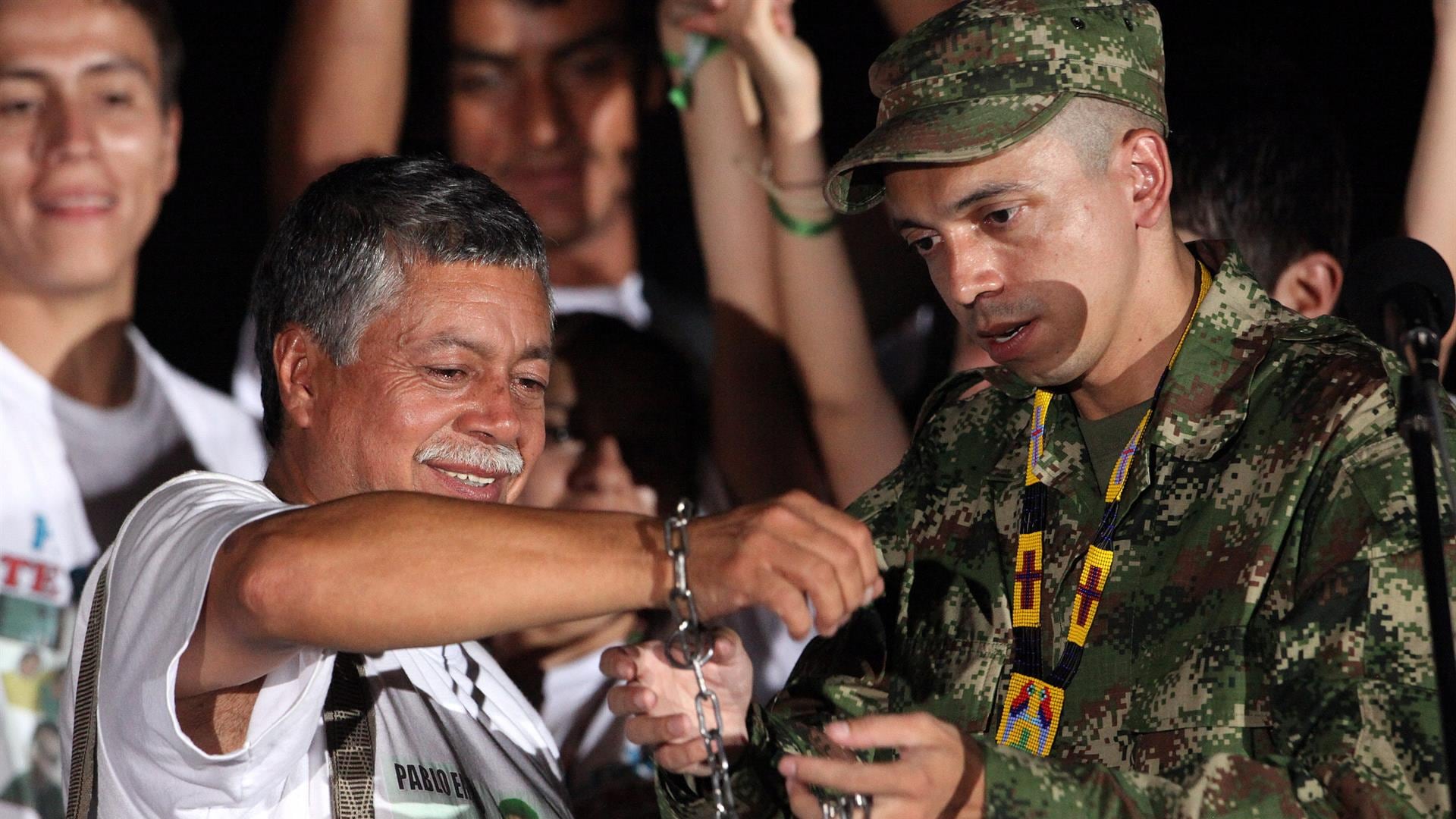 El sargento Pablo Emilio Moncayo ayuda a su padre, el profesor Gustavo Moncayo, a cortar las cadenas que portaba en su cuello y sus manos.