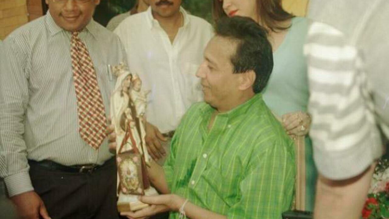 Diomedes Díaz admirando una figura de la Virgen del Carmen.