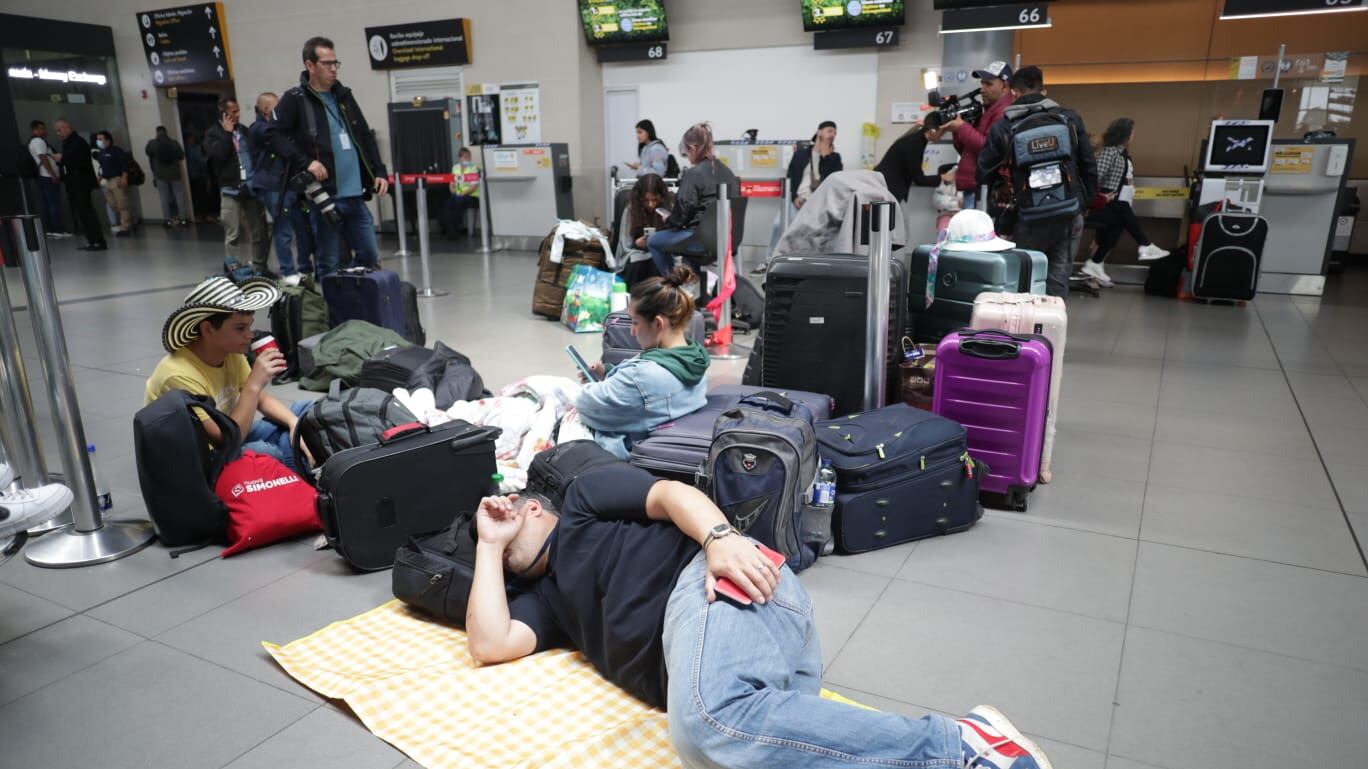 Pasajeros afectados por el cese de operaciones de Viva Air esperan soluciones por parte de la aerolínea y de la Aeronáutica Civil. Mientras tanto, cientos de personas esperan en los espacios públicos del Aeropuerto Internacional El Dorado en Bogotá.