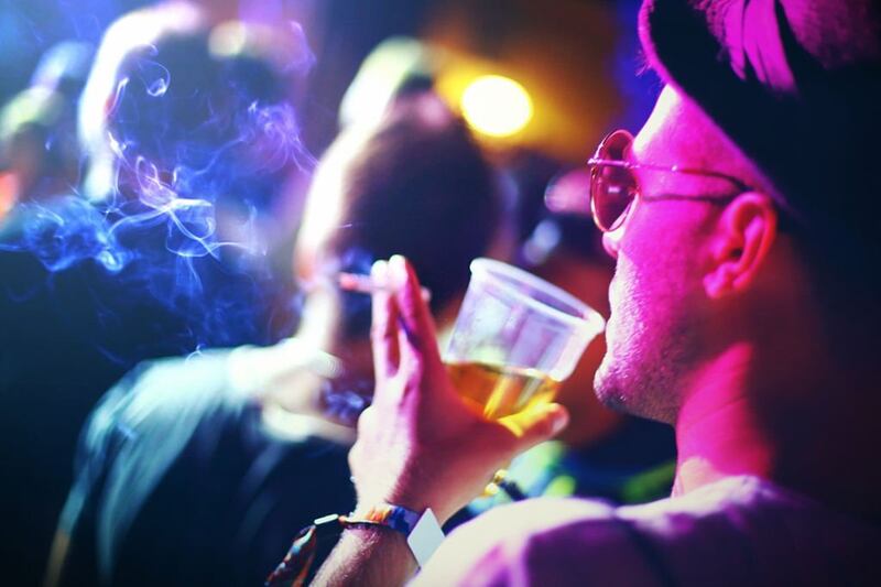 Persona fumando y bebiendo durante una fiesta