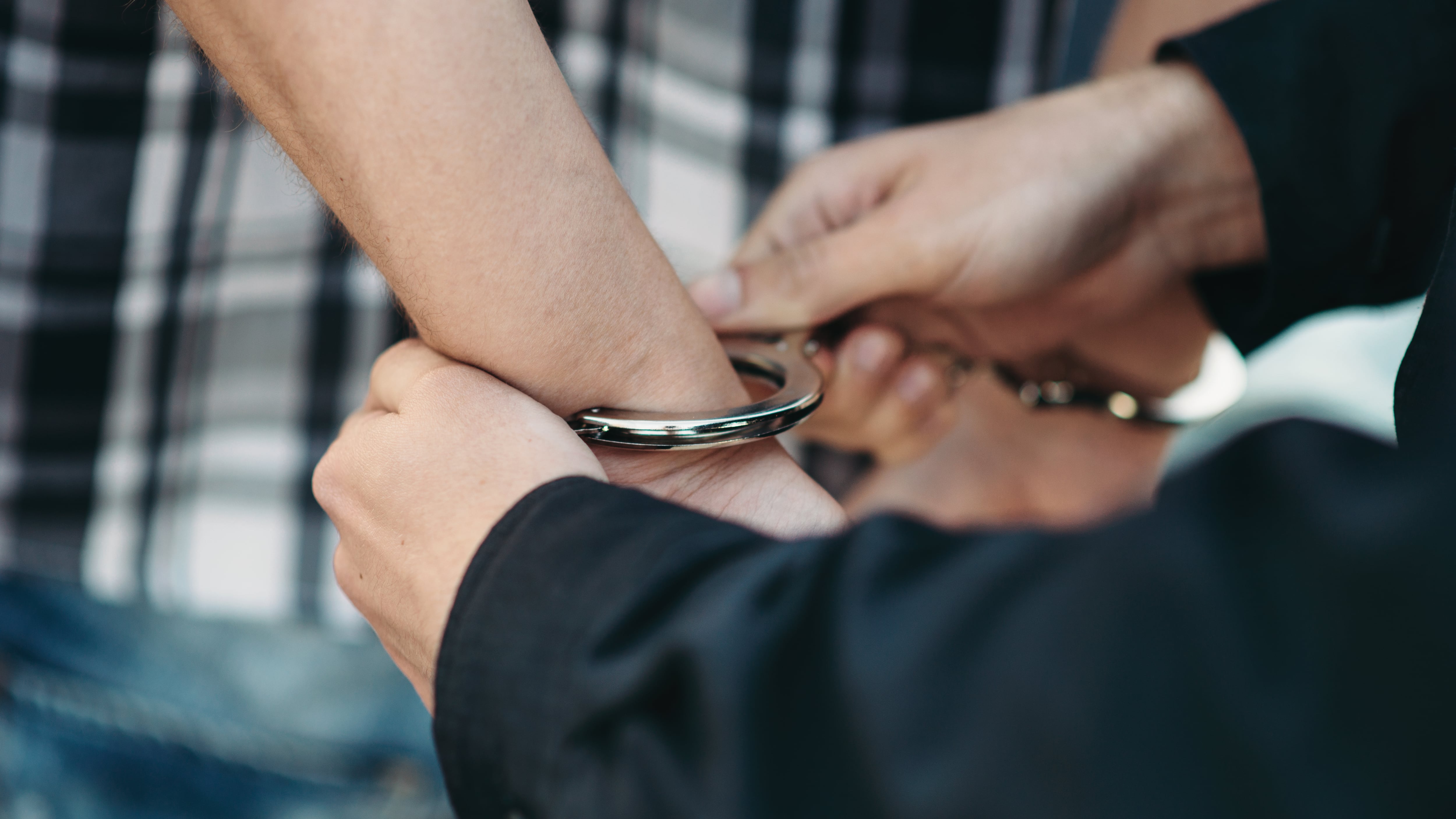 Un policía esposa a un ladrón de coches