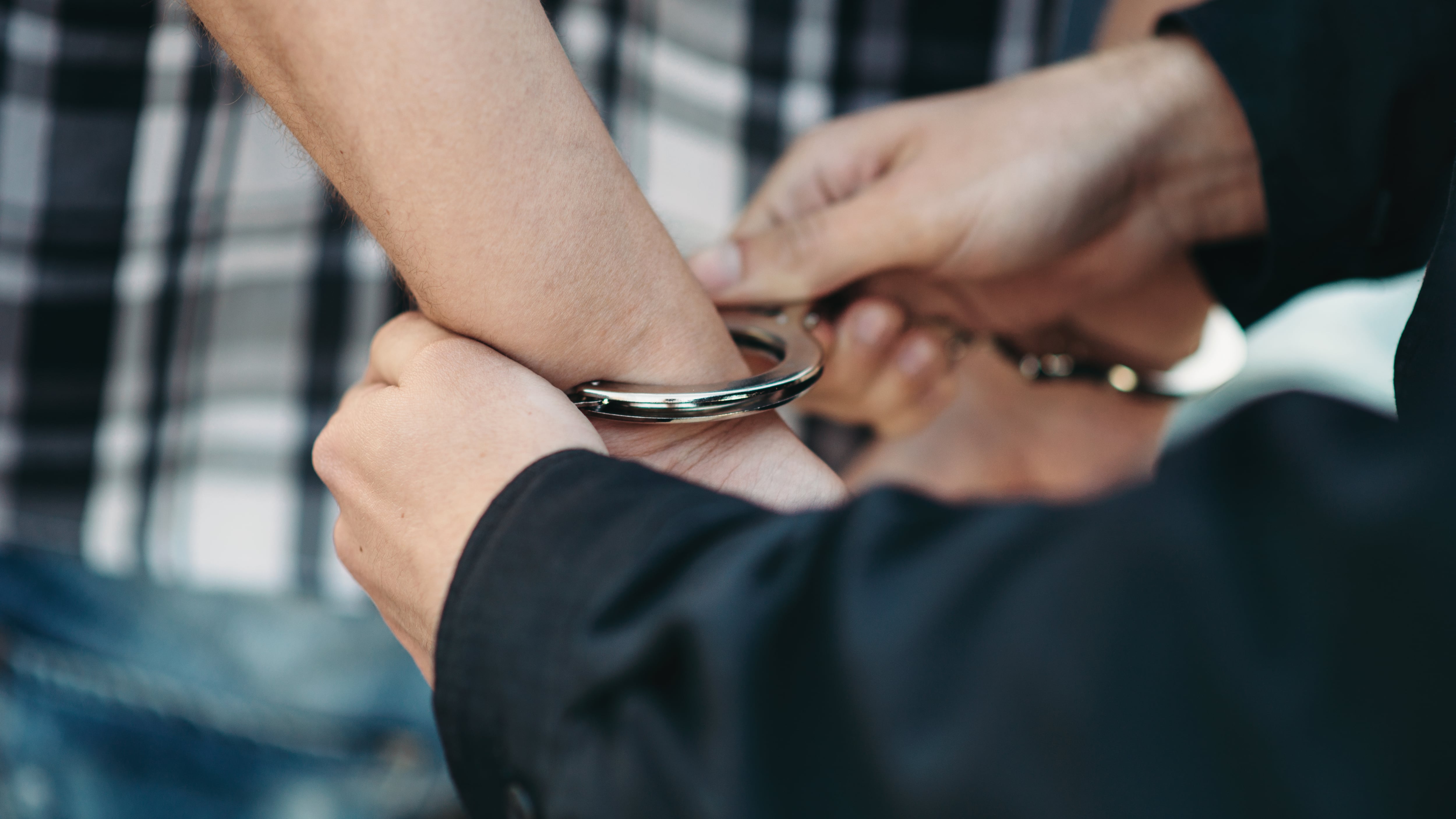 Un policía esposa a un ladrón de coches