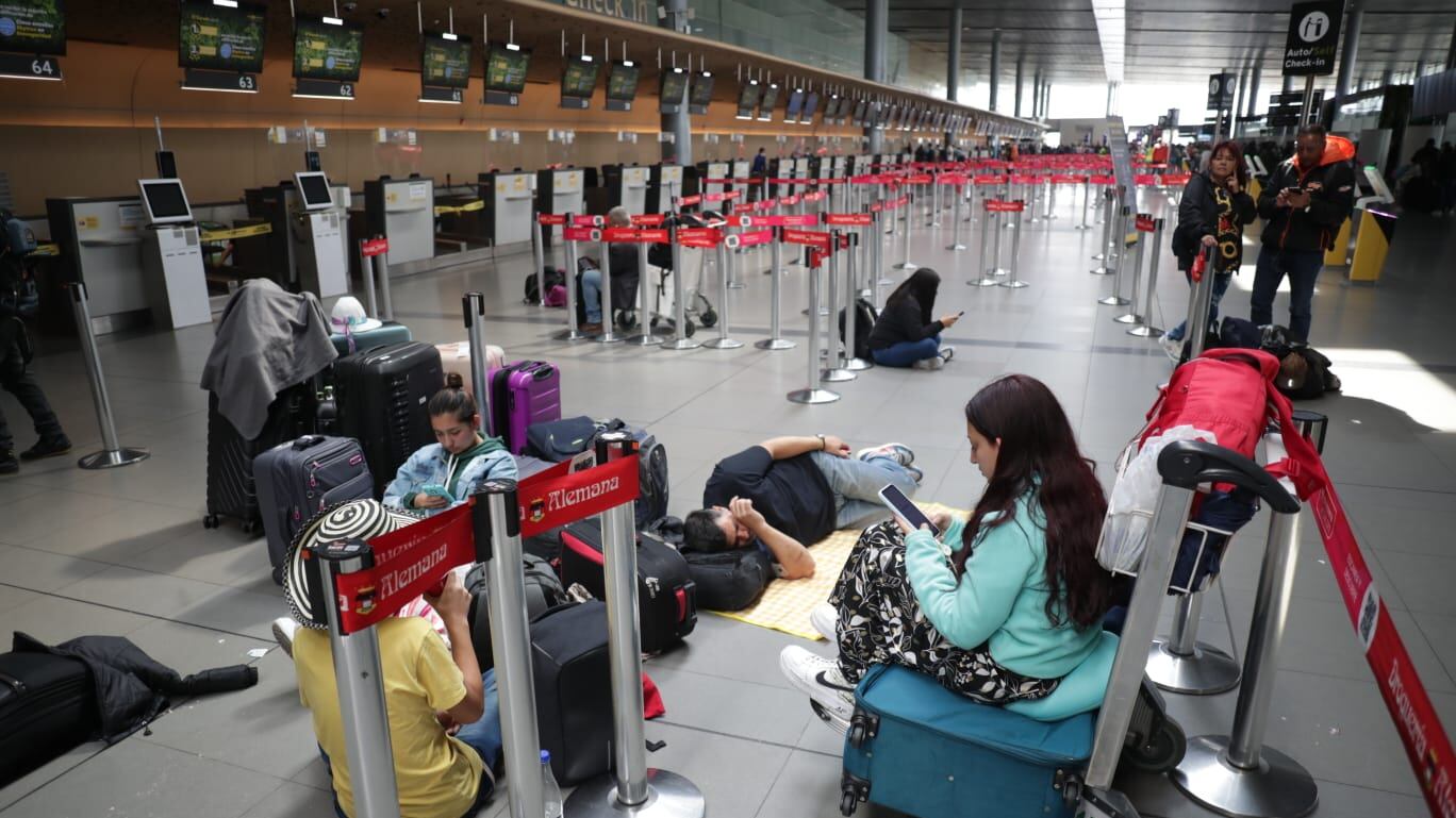 Pasajeros afectados por el cese de operaciones de Viva Air esperan soluciones por parte de la aerolínea y de la Aeronáutica Civil. Mientras tanto, cientos de personas esperan en los espacios públicos del Aeropuerto Internacional El Dorado en Bogotá.