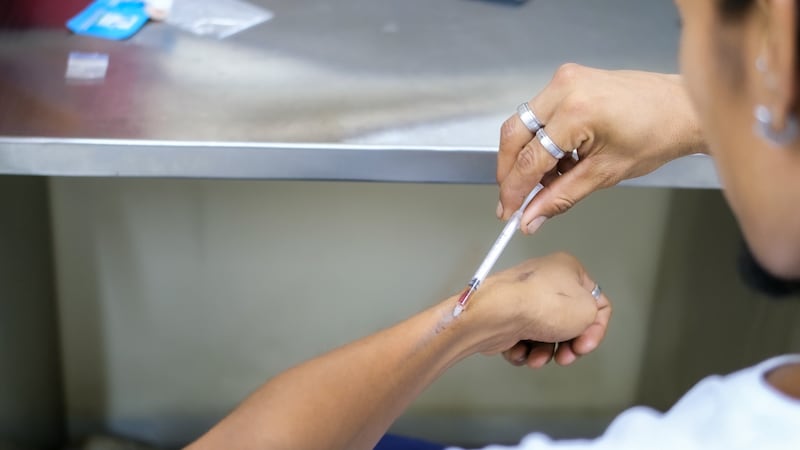 Inyección de heroína con una jeringa y elementos de cuidado en un entorno clínico controlado.