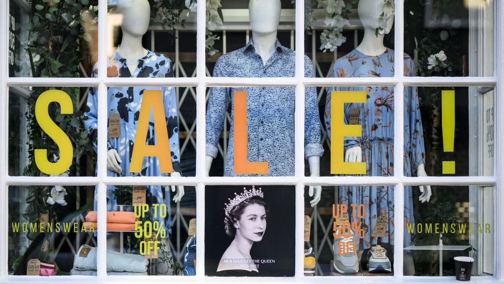 LONDON - SEPTEMBER 17: An image of Queen Elizabeth II is seen in the window of an independent fashion store on September 17, 2022 in Windsor, England. Queen Elizabeth II is lying in state at Westminster Hall until the morning of her funeral to allow members of the public to pay their last respects. Elizabeth Alexandra Mary Windsor was born in Bruton Street, Mayfair, London on 21 April 1926. She married Prince Philip in 1947 and acceded to the throne of the United Kingdom and Commonwealth on 6 February 1952 after the death of her Father, King George VI. Queen Elizabeth II died at Balmoral Castle in Scotland on September 8, 2022, and is succeeded by her eldest son, King Charles III.