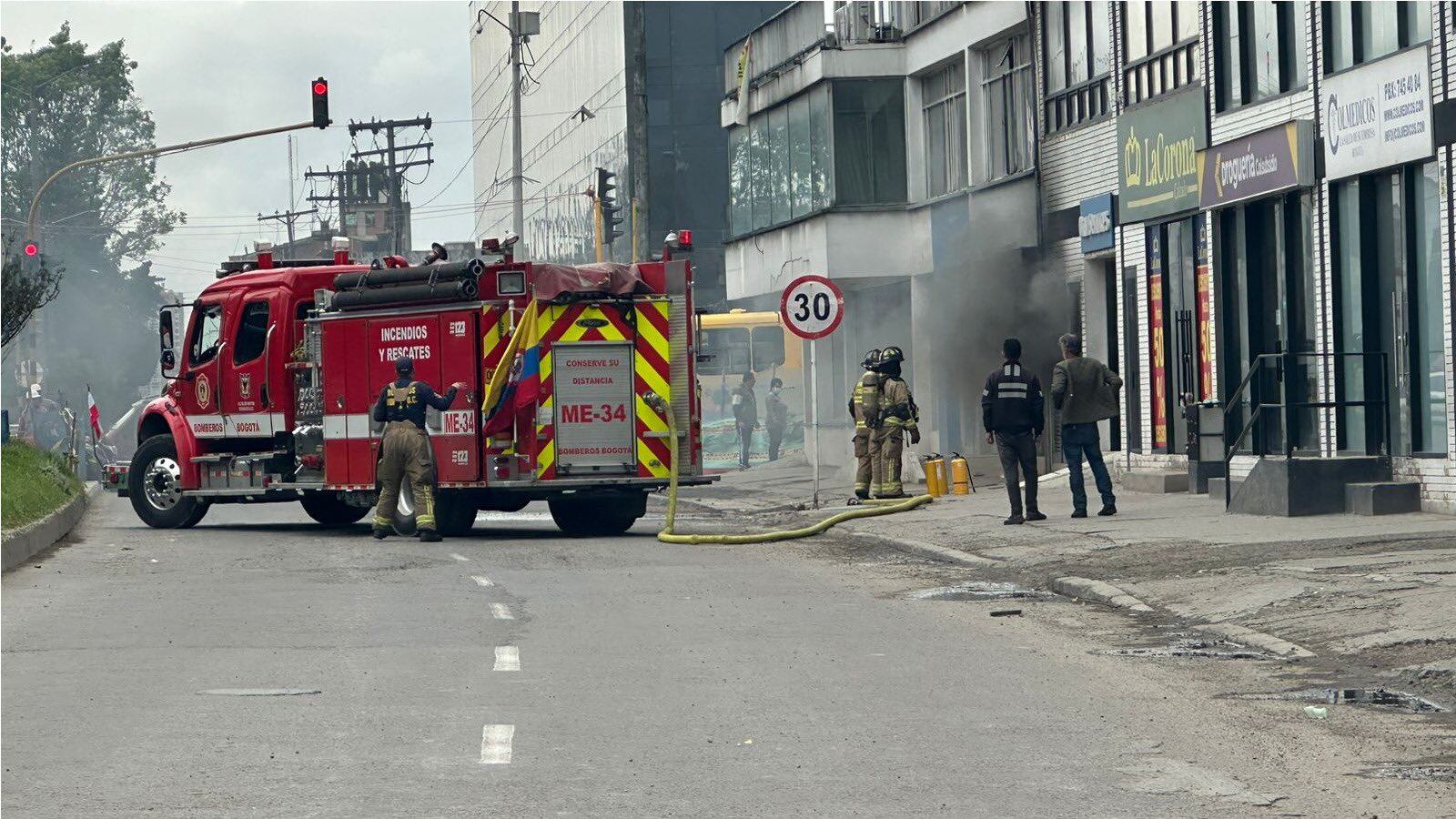 Bomberos de Bogotá controlan las llamas de un incendio.